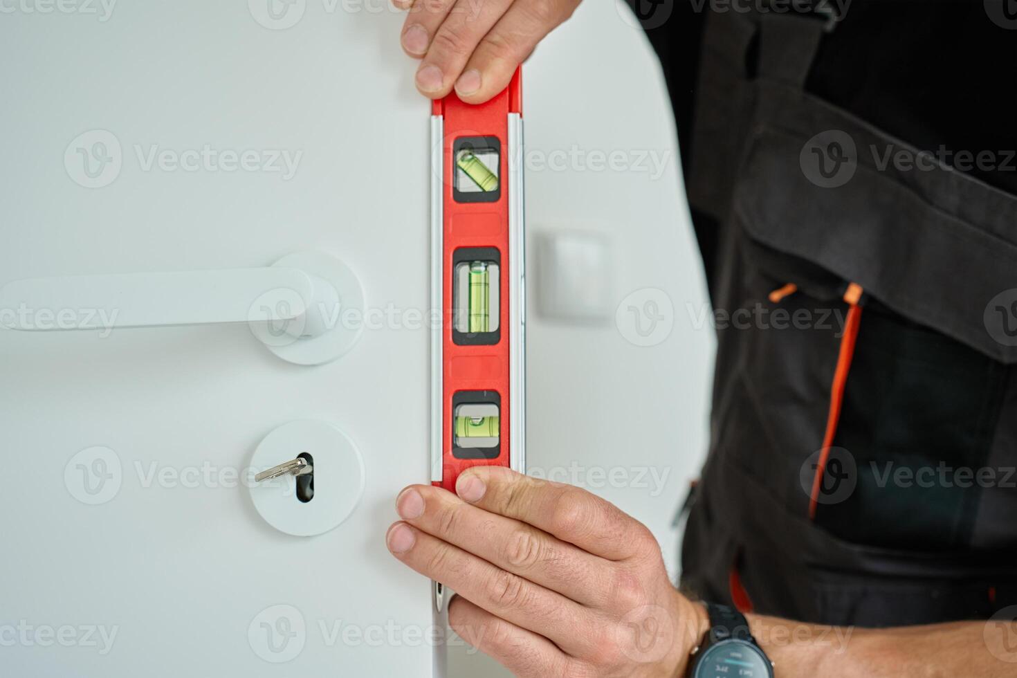 Close up of carpenter Checking Door Alignment with Spirit Level photo