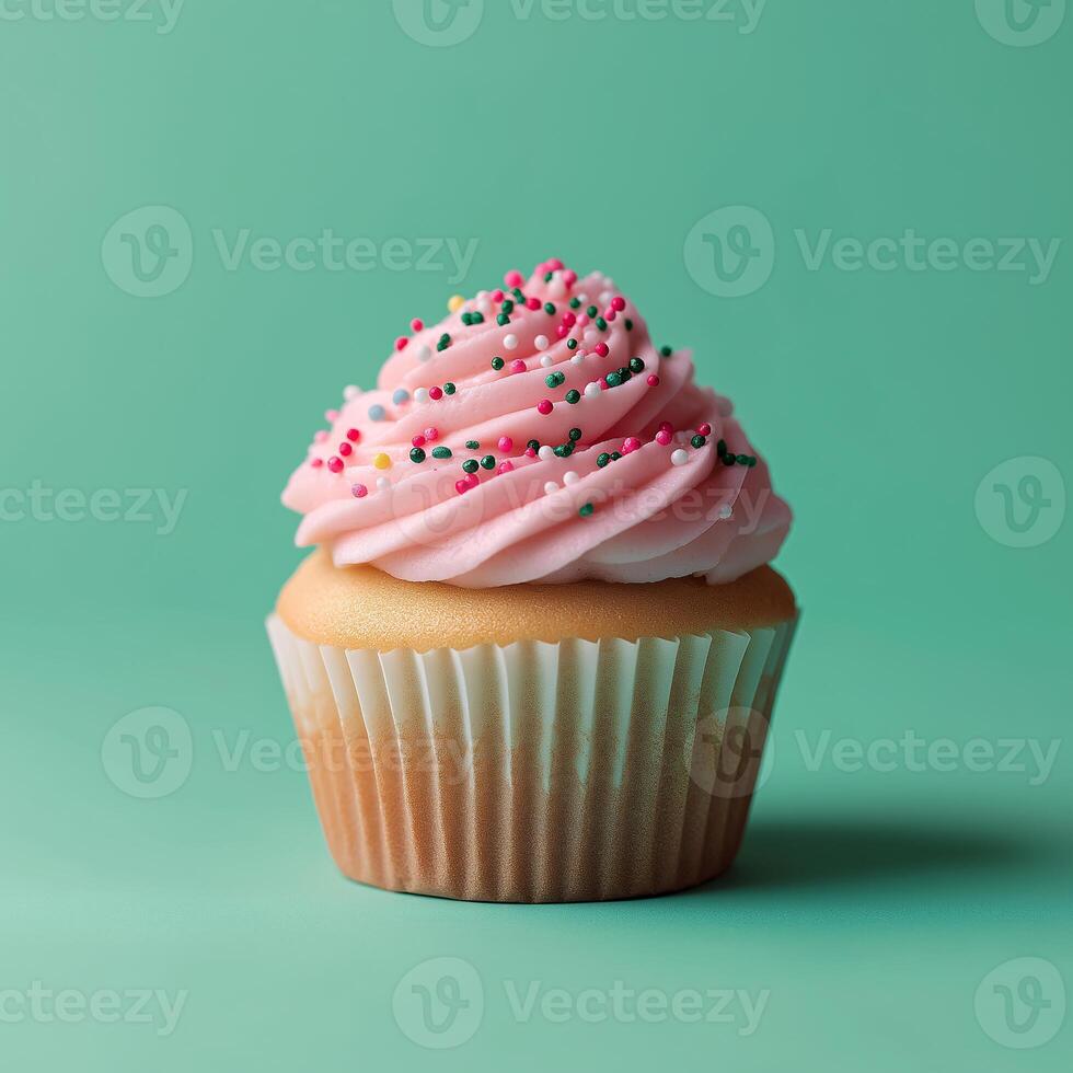 A cupcake with pink frosting on a green background photo
