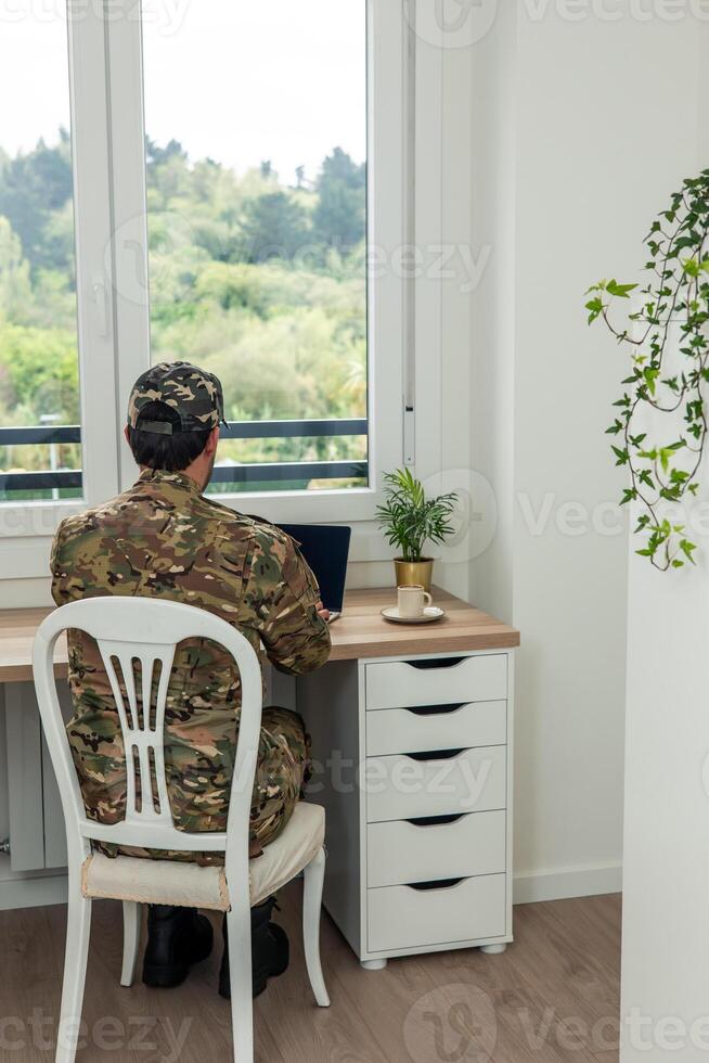 vertical Soldier working from home using laptop computer photo