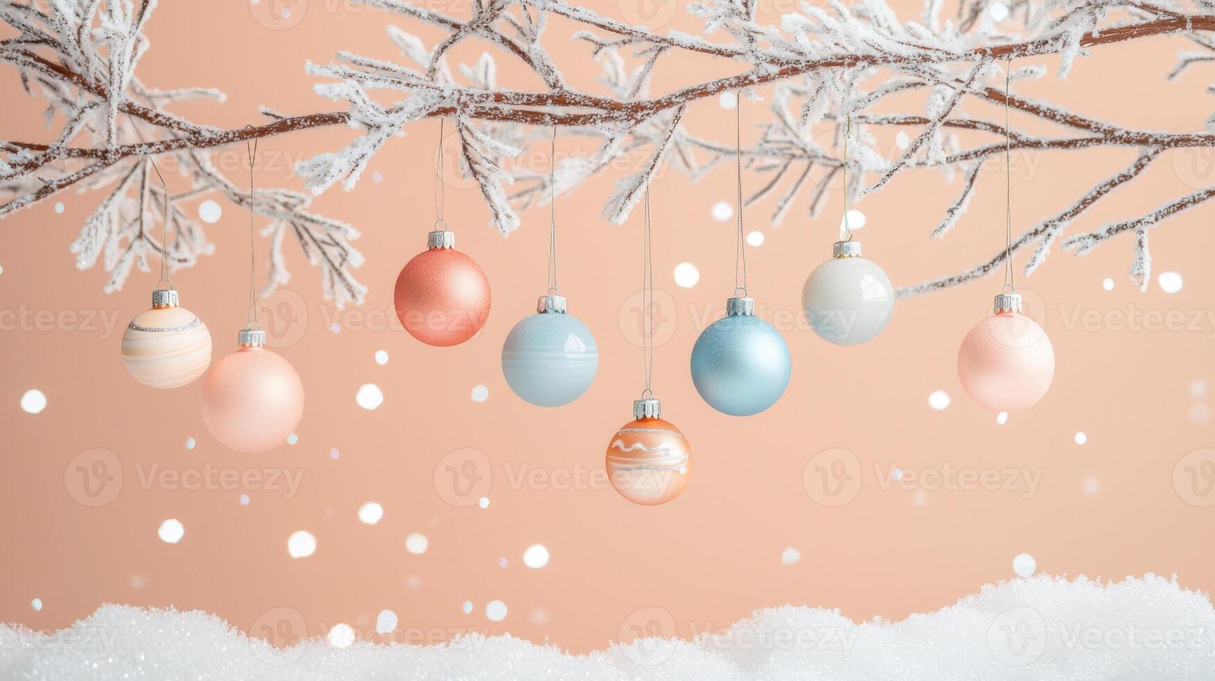 Delicate pastel ornaments hang from a frosted branch against a soft peach backdrop photo