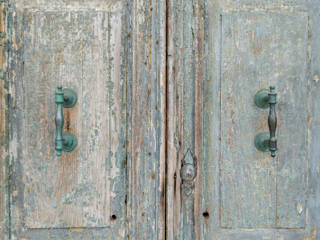 Weathered double wooden door with vintage handles photo