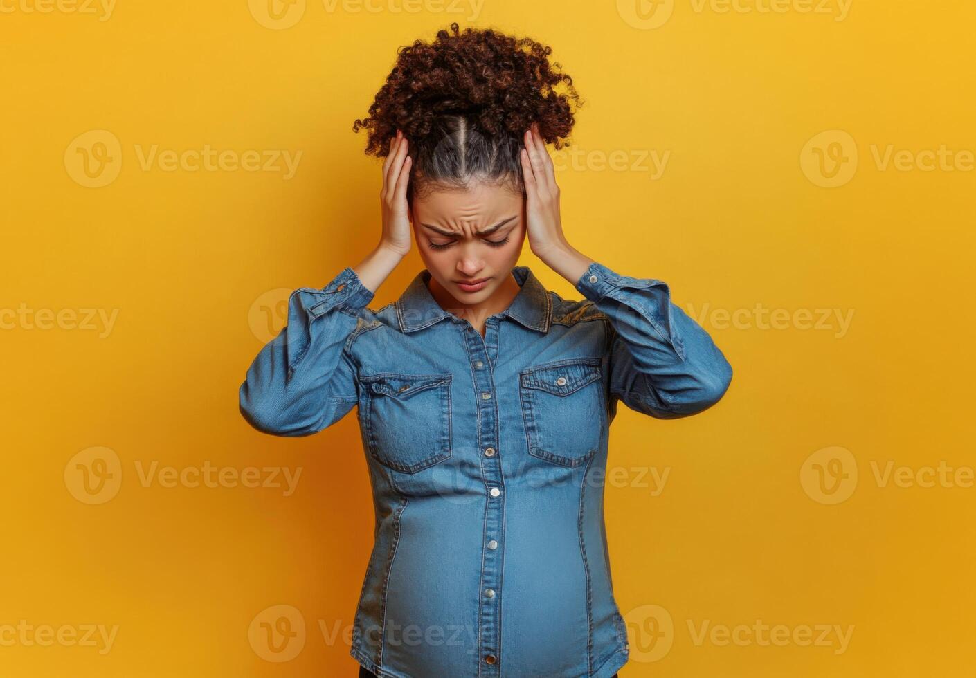 Pregnant Woman Experiencing Headache or Discomfort During Pregnancy on Yellow Background photo