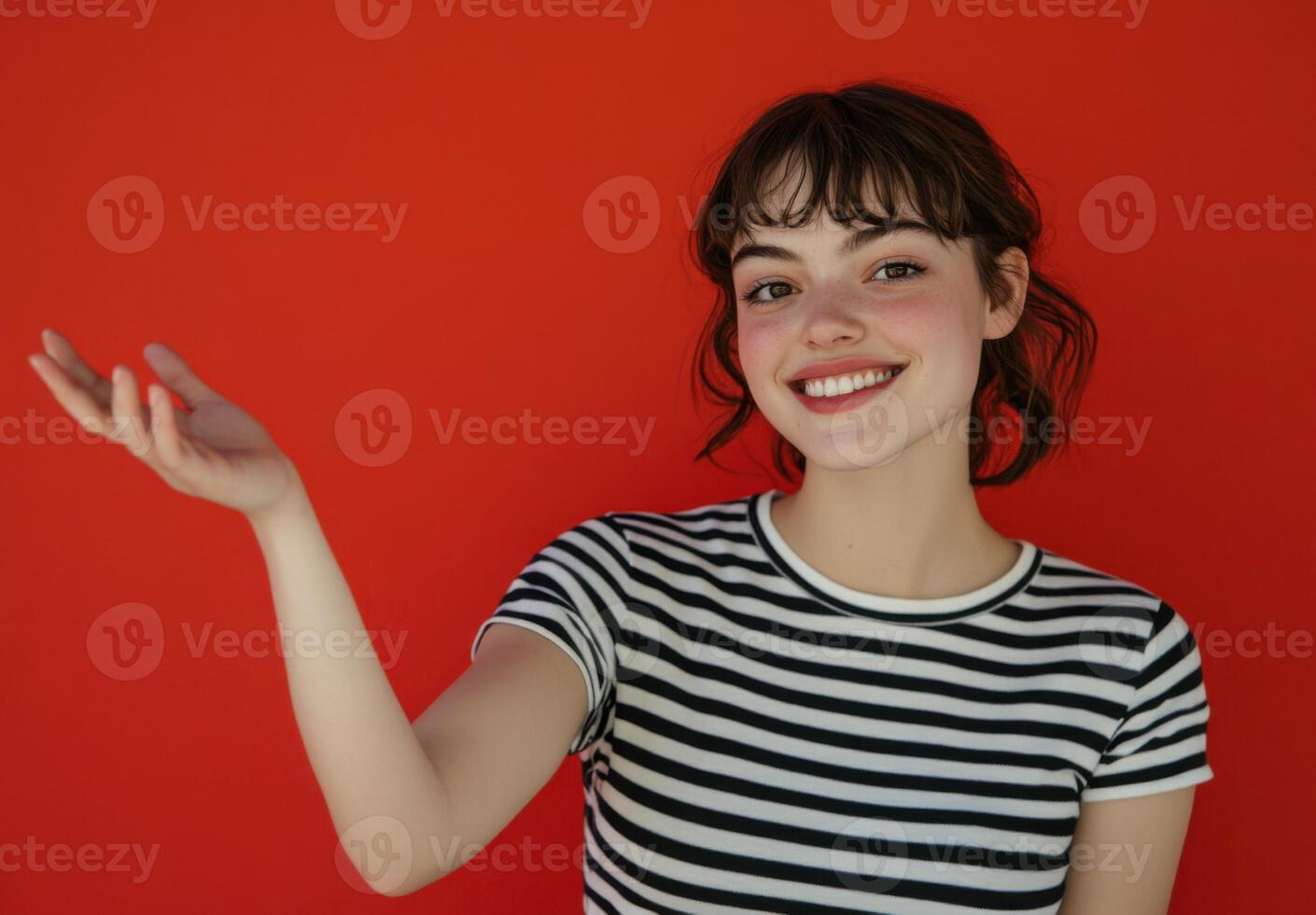 Portrait of a Smiling Young Woman with Bangs Wearing a Striped Shirt Against a Red Background photo