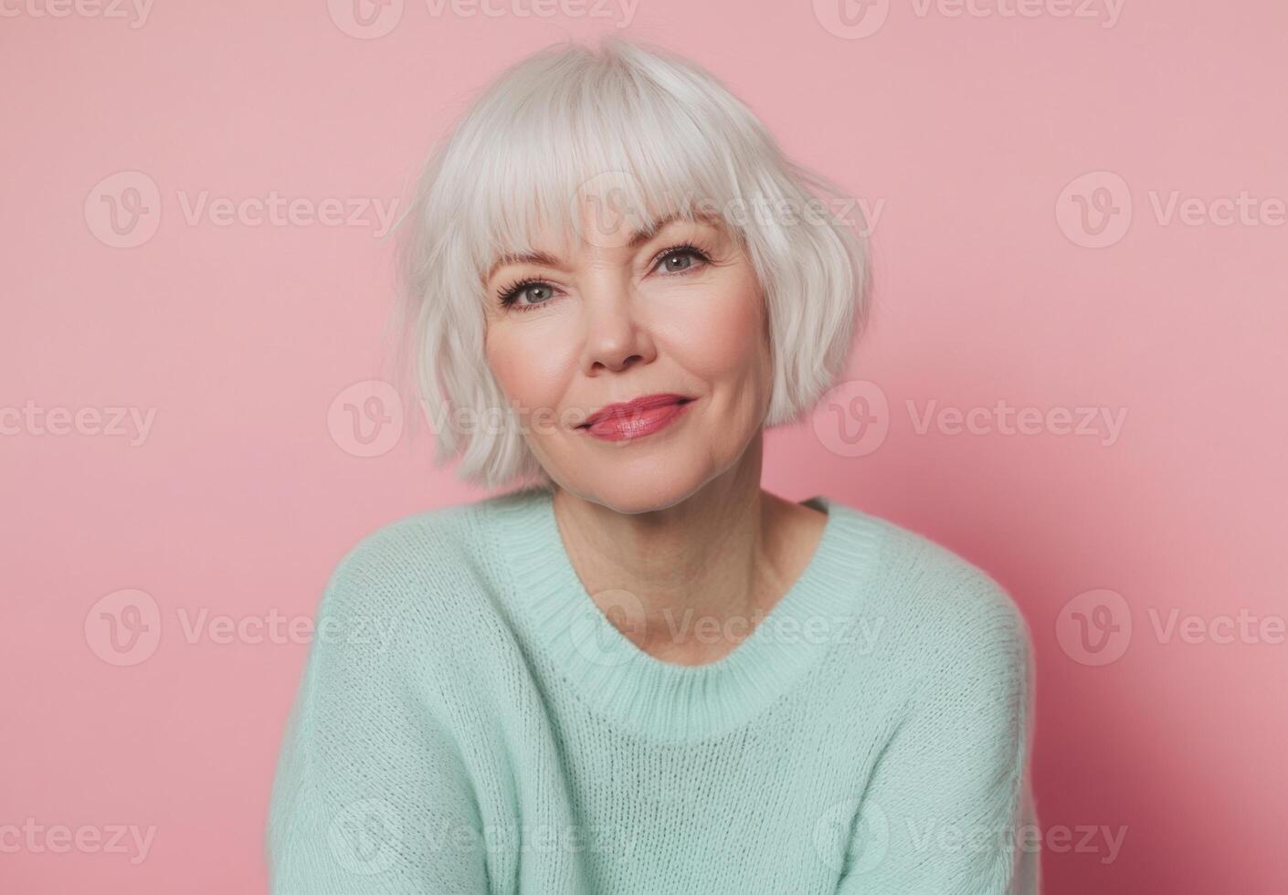 Portrait of a Serene Mature Woman with Short White Hair Against a Pink Background photo