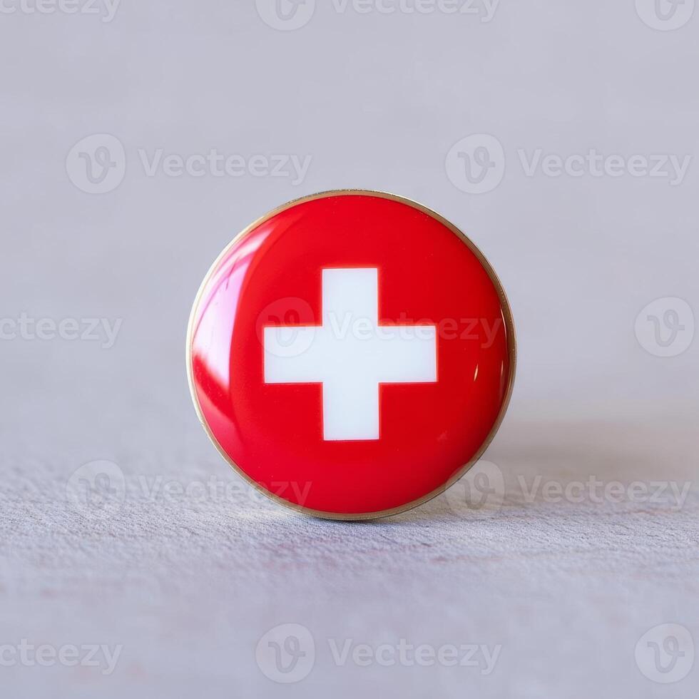A red and white swiss flag pin on a white background photo