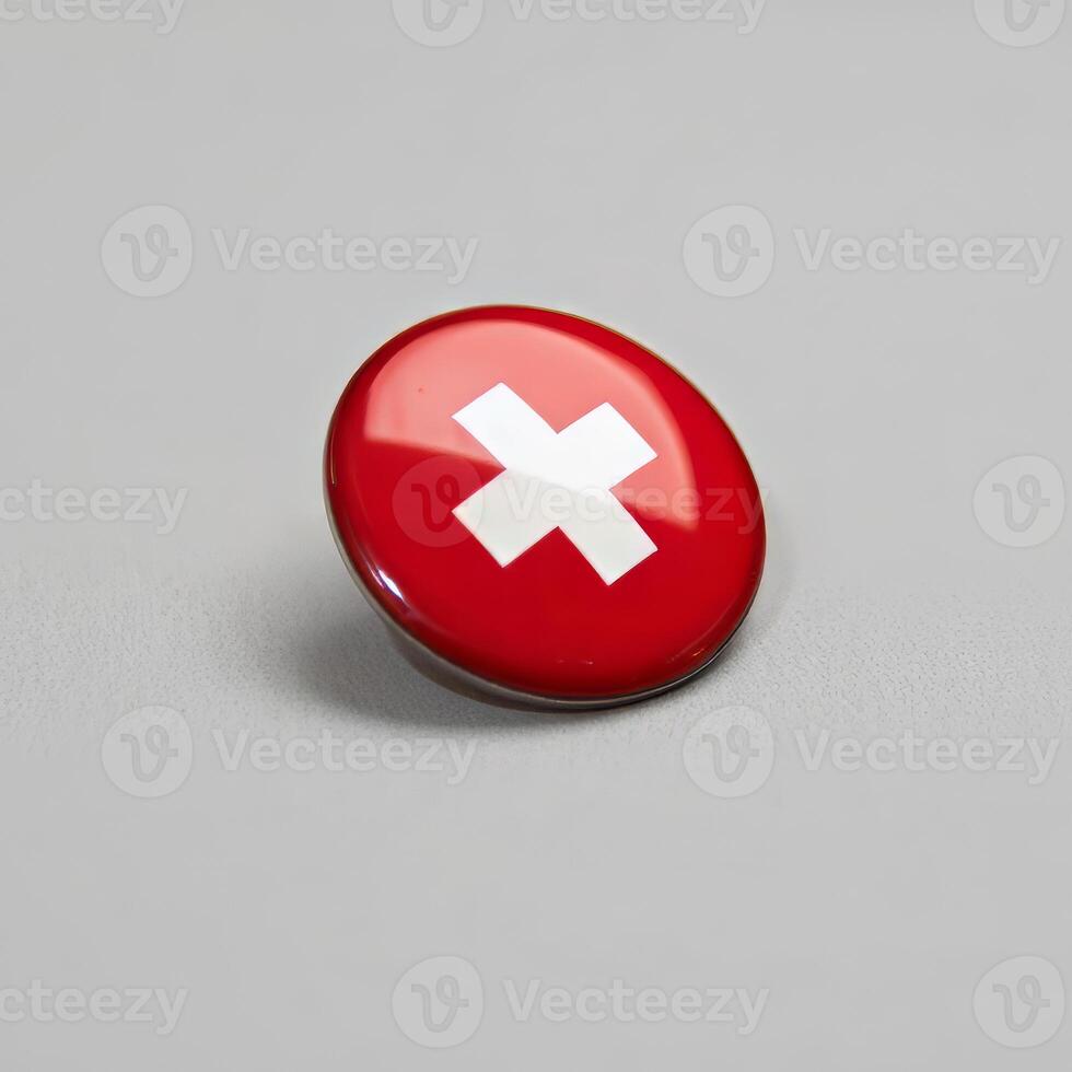 A red button with a white cross on it photo