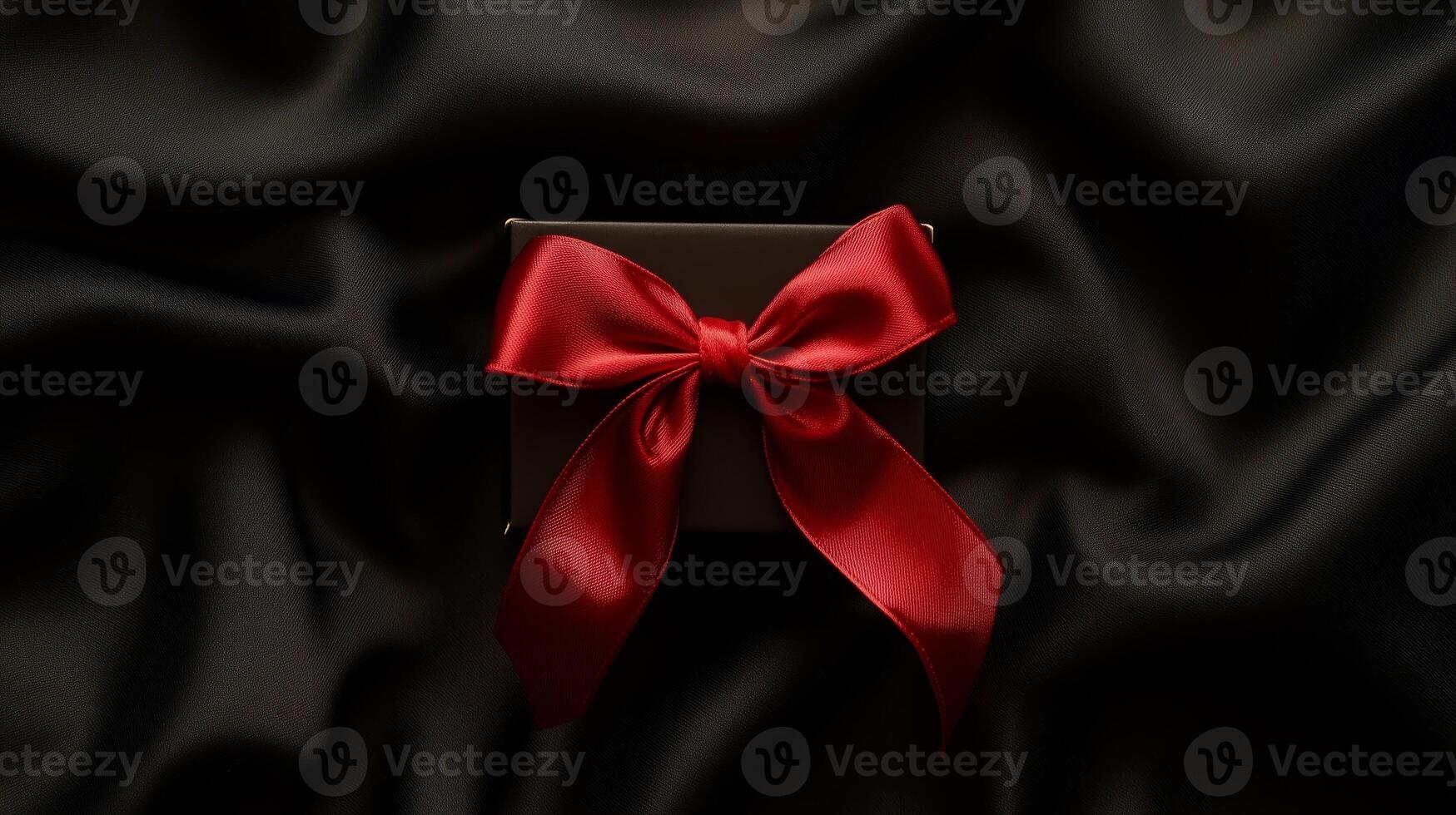 Gift box with a red bow on a fabric background photo