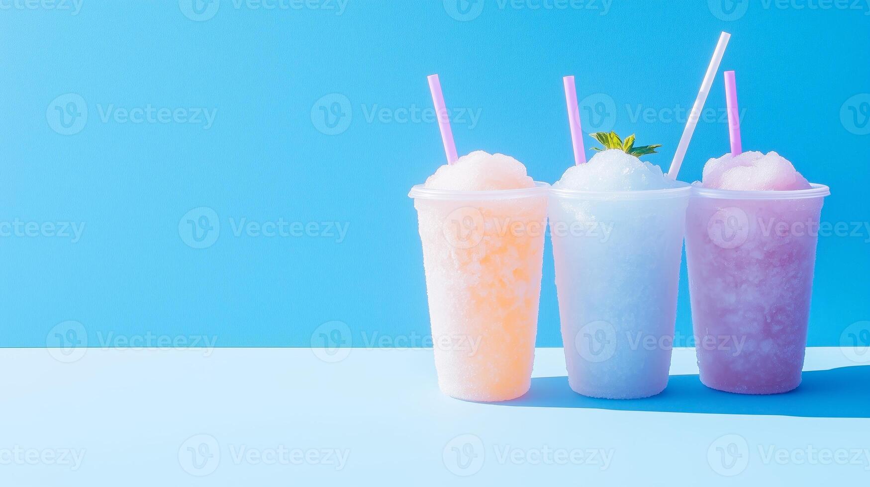 Three different colored drinks in plastic cups on a blue background photo