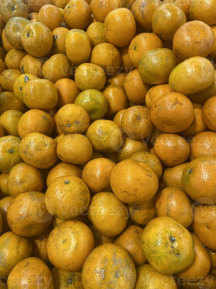 Portrait Shot of Fresh Malang Oranges Stacked in Traditional Market Display photo