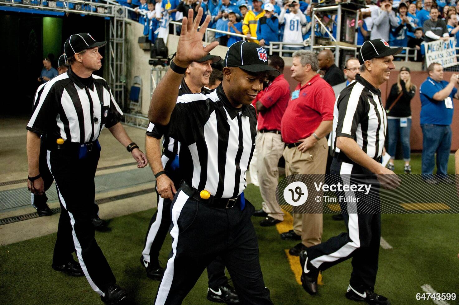 NFL referee Terrence Miles (111) waves as he walks into the field before  the game between the Detroit Lions and the Minnesota Vikings at Ford Field.  64743599 Editorial Image