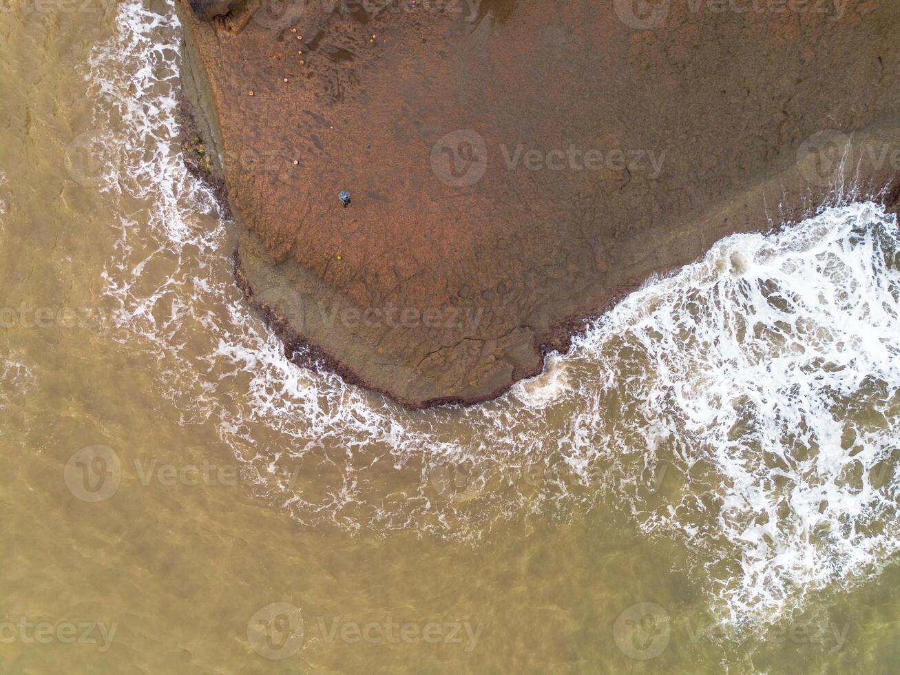 An aerial view of a beach with a person on a surfboard photo
