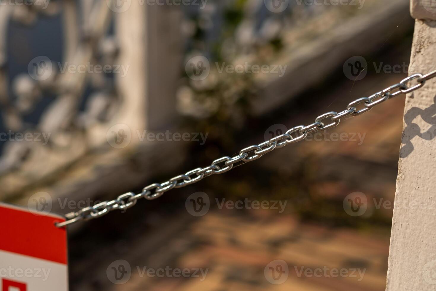 Details of a chain barrier at Peterhof revealing a glimpse of the historic architecture photo