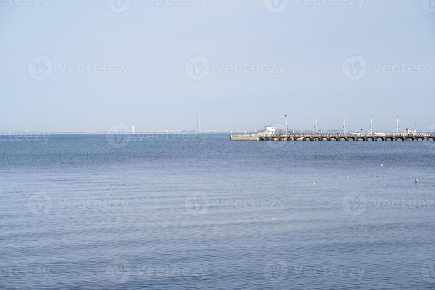 Serene view of the calm waters at Peterhof with a pier extending into the distance photo