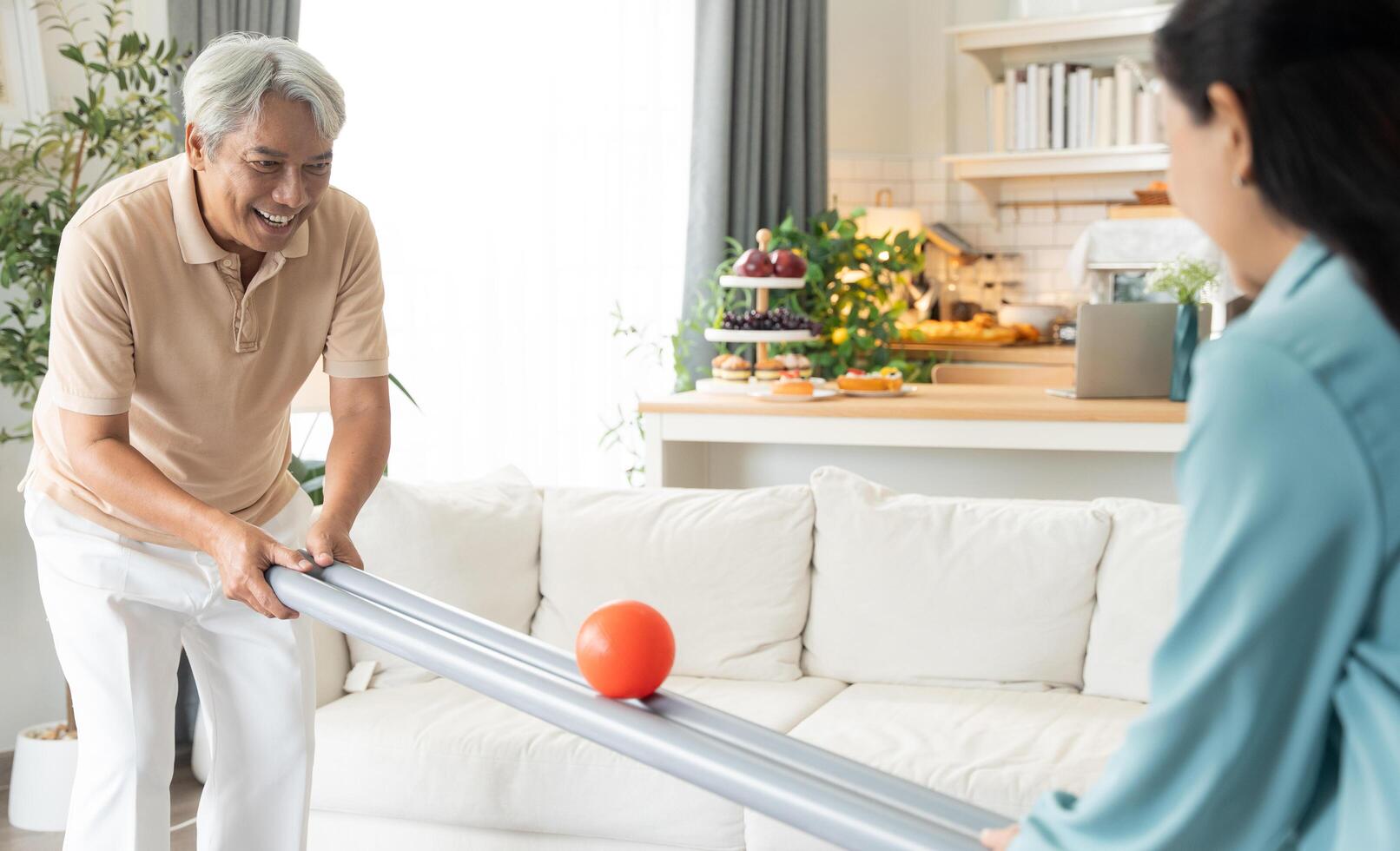 Retired couple playing rolling ball for practice balance and concentrate in the living room photo