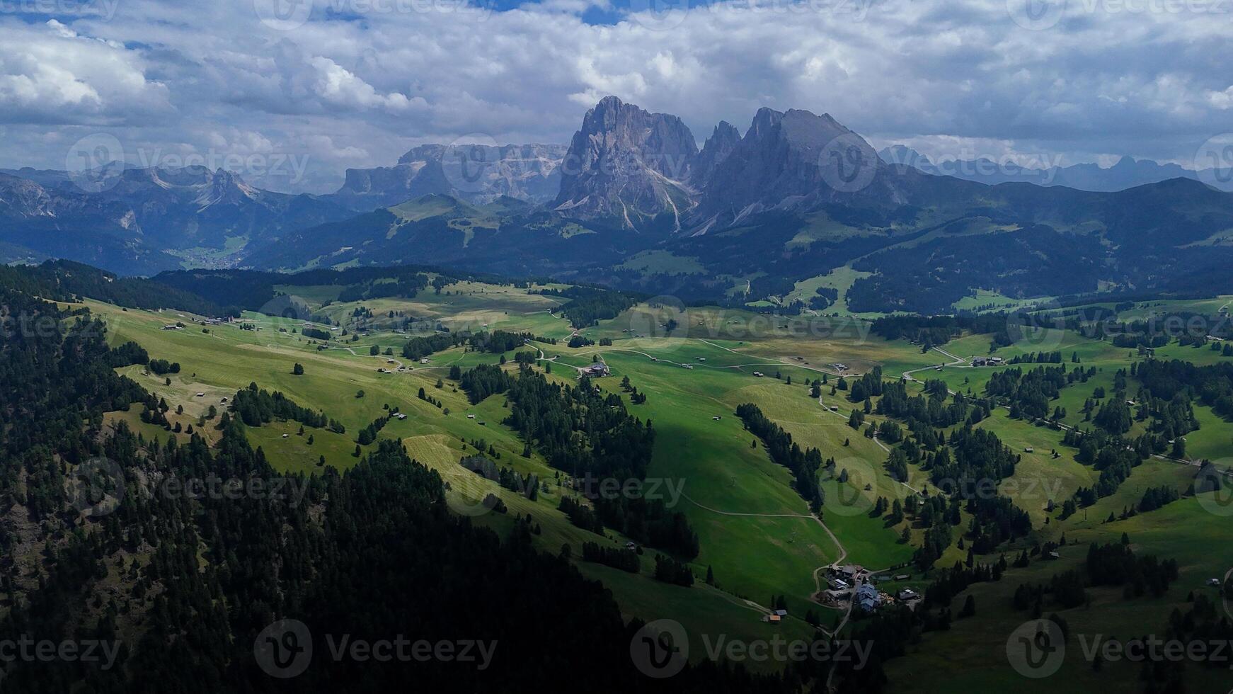 Expansive green valleys and towering mountains capture the breathtaking beauty of the Dolomites in summer photo