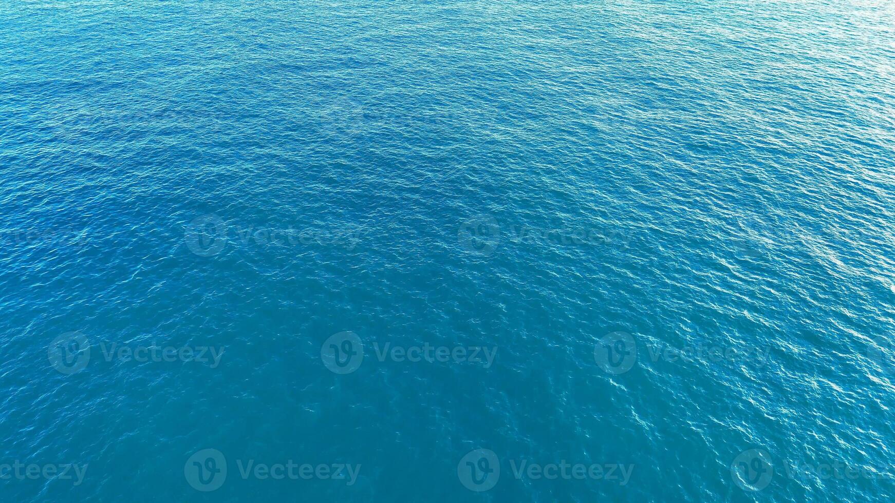 Blue serenity of the ocean waves gently lapping the shore under a clear sky on a calm summer afternoon photo