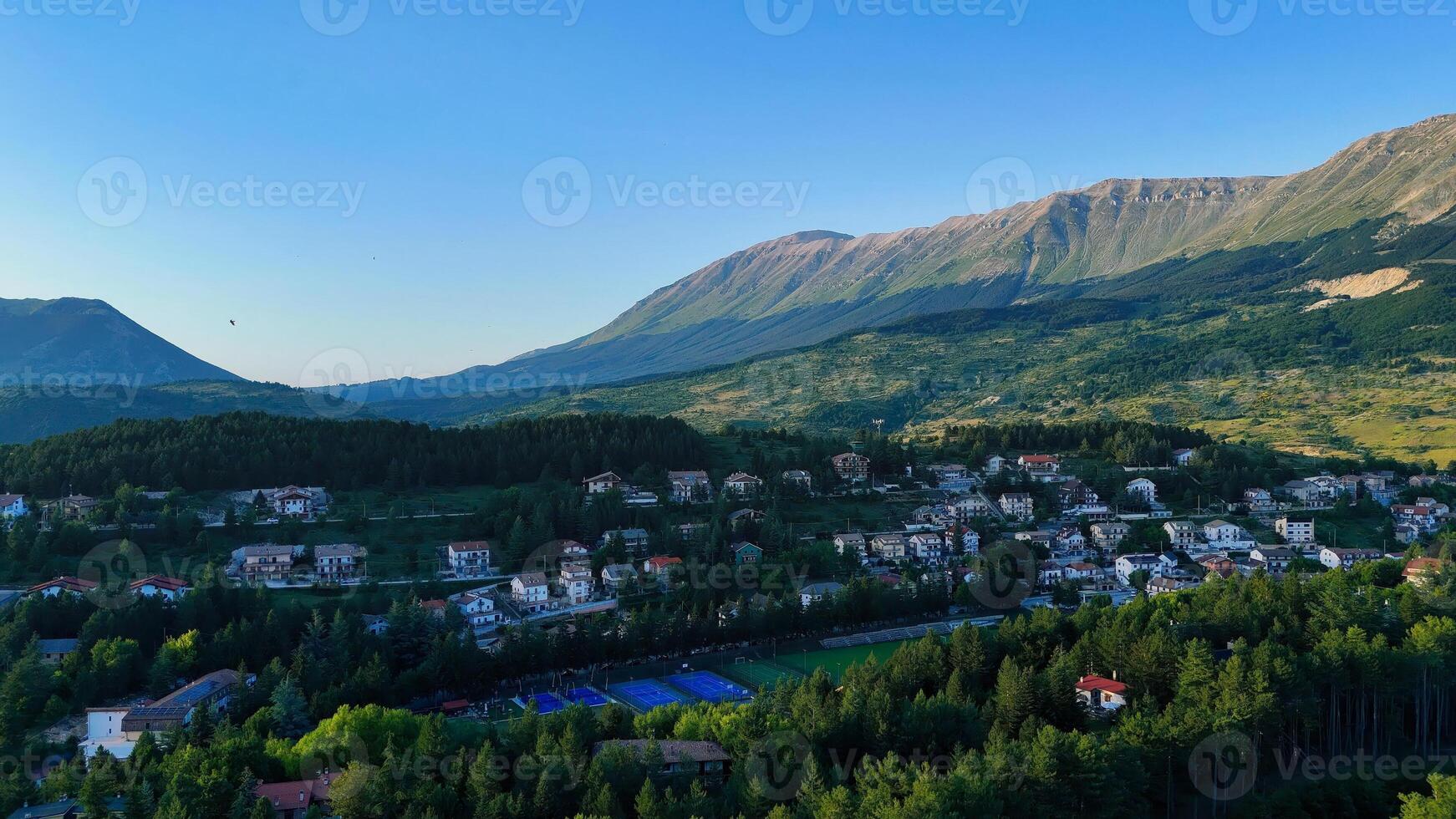 Captivating view of serene mountains and quaint village nestled in lush greenery during the golden hour photo