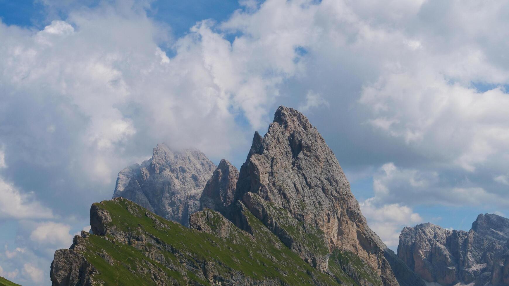 Majestic mountain peaks rise against a brilliant blue sky adorned with fluffy white clouds in the heart of nature's masterpiece photo