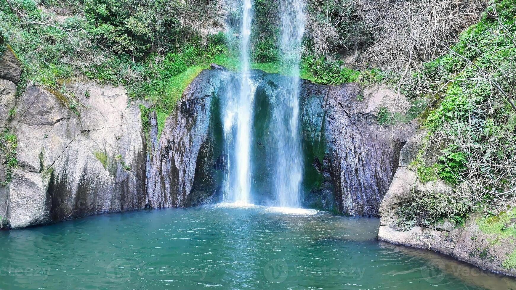 Discovering hidden beauty at a serene waterfall surrounded by lush greenery in a tranquil natural haven photo