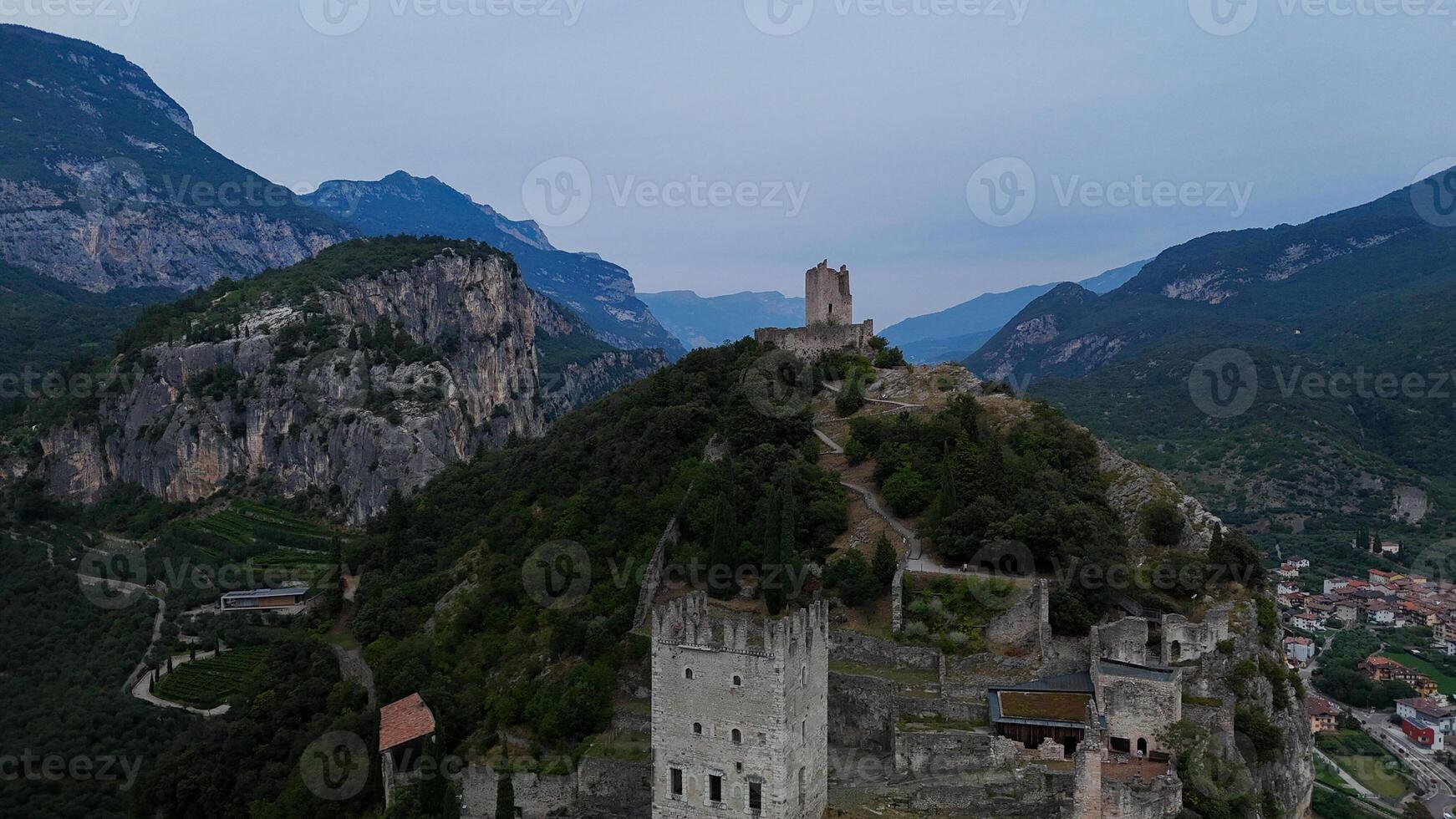 Exploring ancient ruins atop a majestic mountain overlooking a serene valley at twilight photo