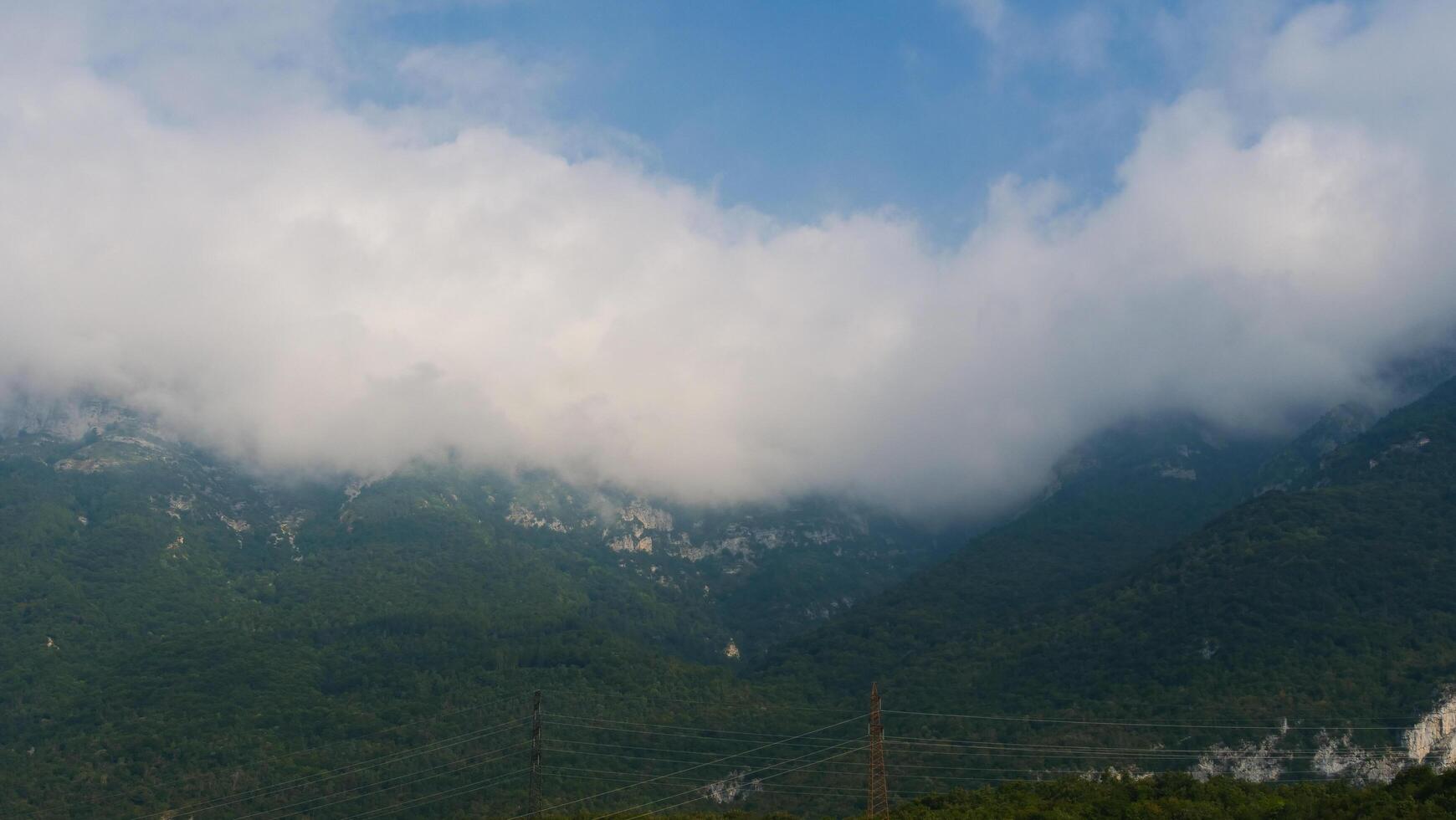 Misty mountains under a blue sky with rolling clouds revealing secrets of nature in a tranquil landscape photo