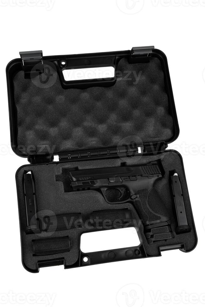 Tactical black pistol with dual magazines and grip modules stored in a hard foam-lined carry case photo