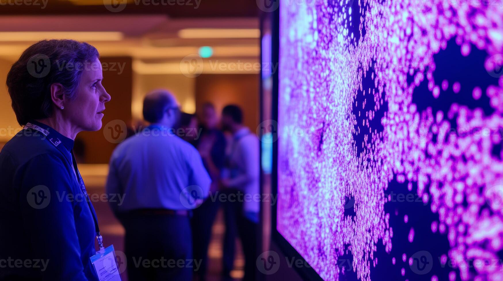 Scientist looking at large screen displaying big data visualization with purple particles simulating complex information analysis in a conference setting photo