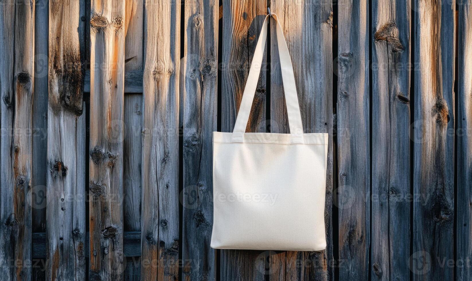 A white canvas bag is hanging on a wooden wall photo