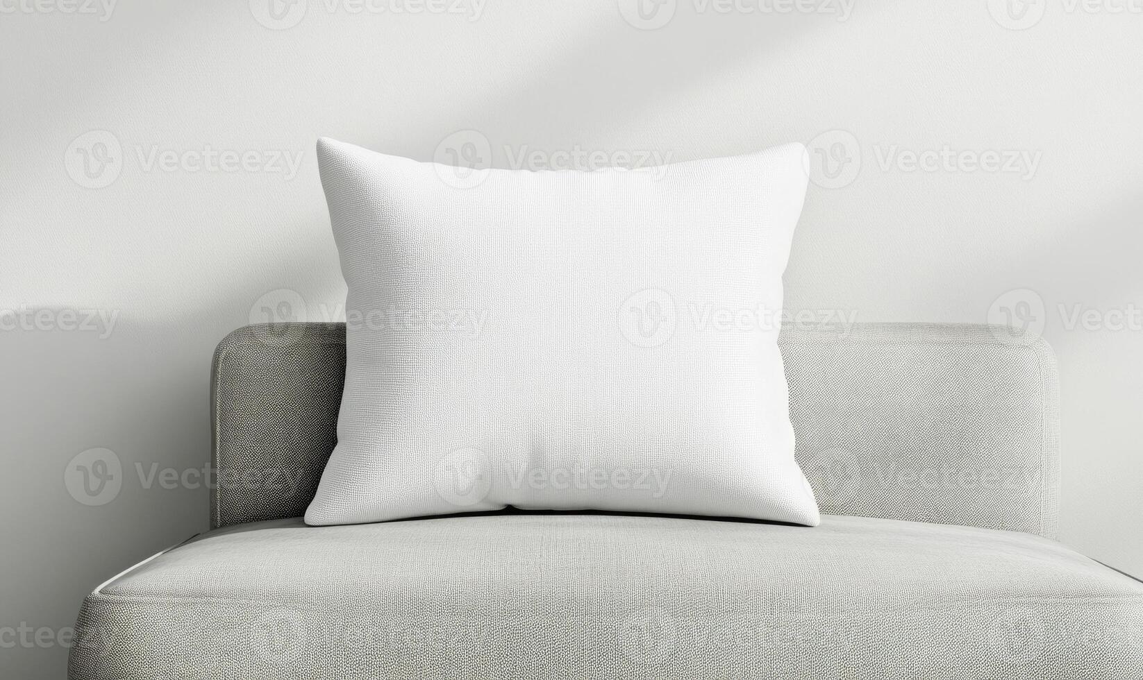 a white pillow on a gray chair in front of a window photo