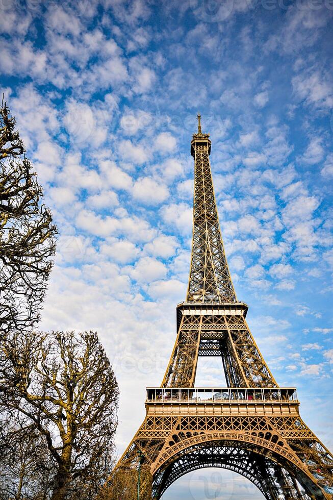 Eiffel Tower against a blue sky with scattered clouds photo