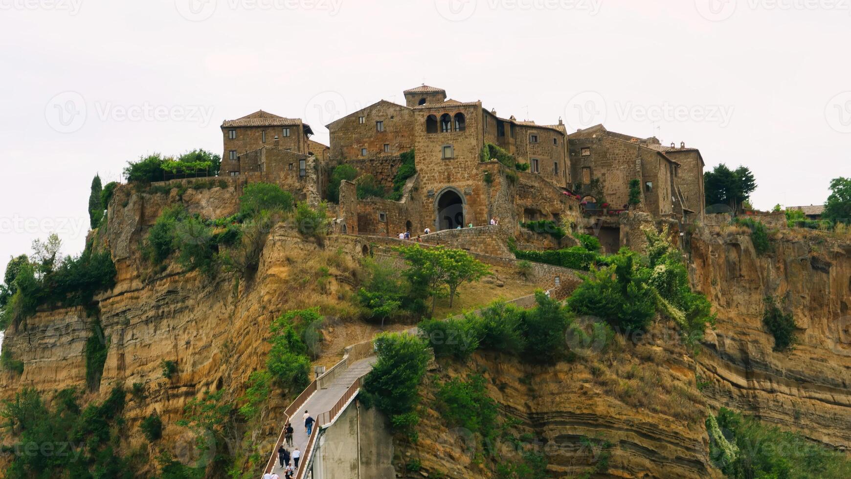 Exploring the ancient hilltop village with stone buildings nestled among dramatic cliffs at dusk photo