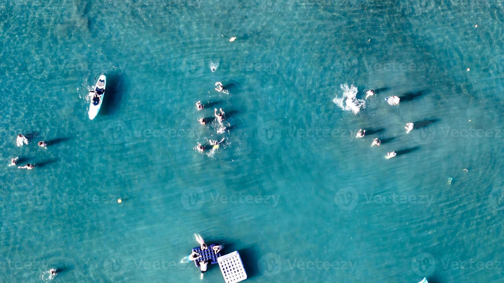 Floating in paradise, people enjoy sunny day with crystal clear waters and playful activities in vibrant tropical setting photo