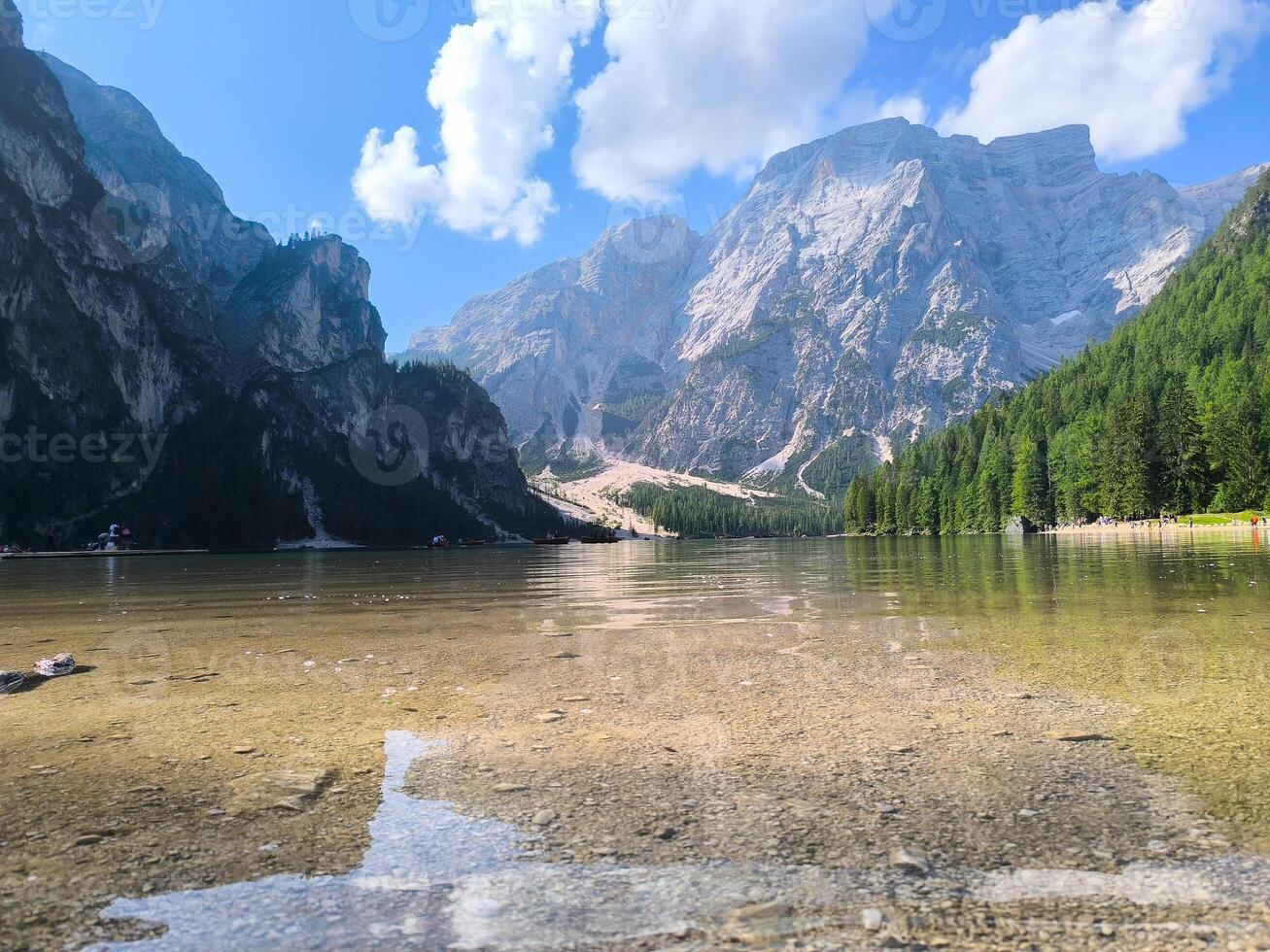Beautiful lake surrounded by majestic mountains under a bright blue sky on a sunny day in the Dolomites photo
