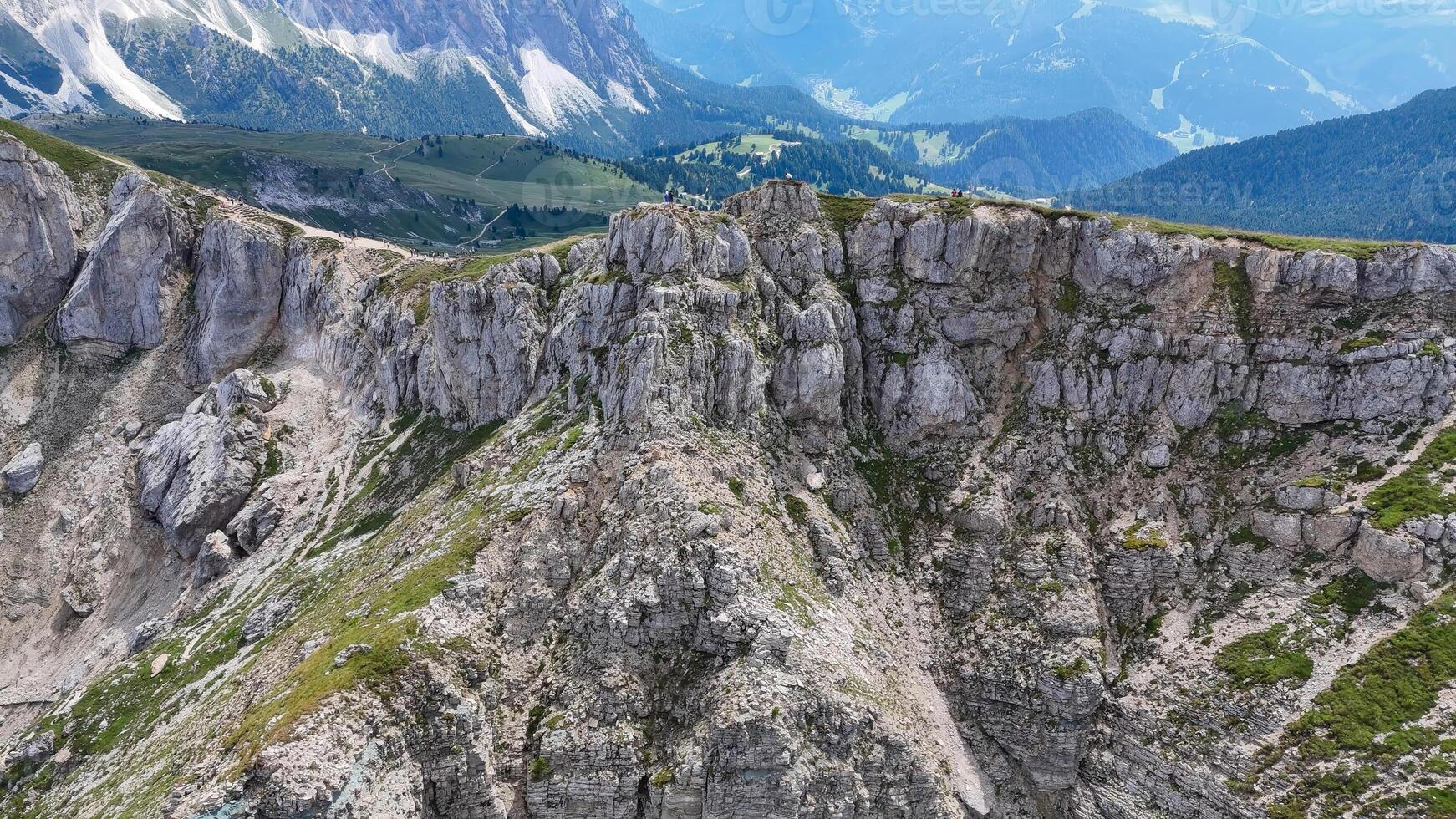 Majestic mountain cliffs rise over tranquil valleys under a bright blue sky in the heart of nature's untouched paradise photo