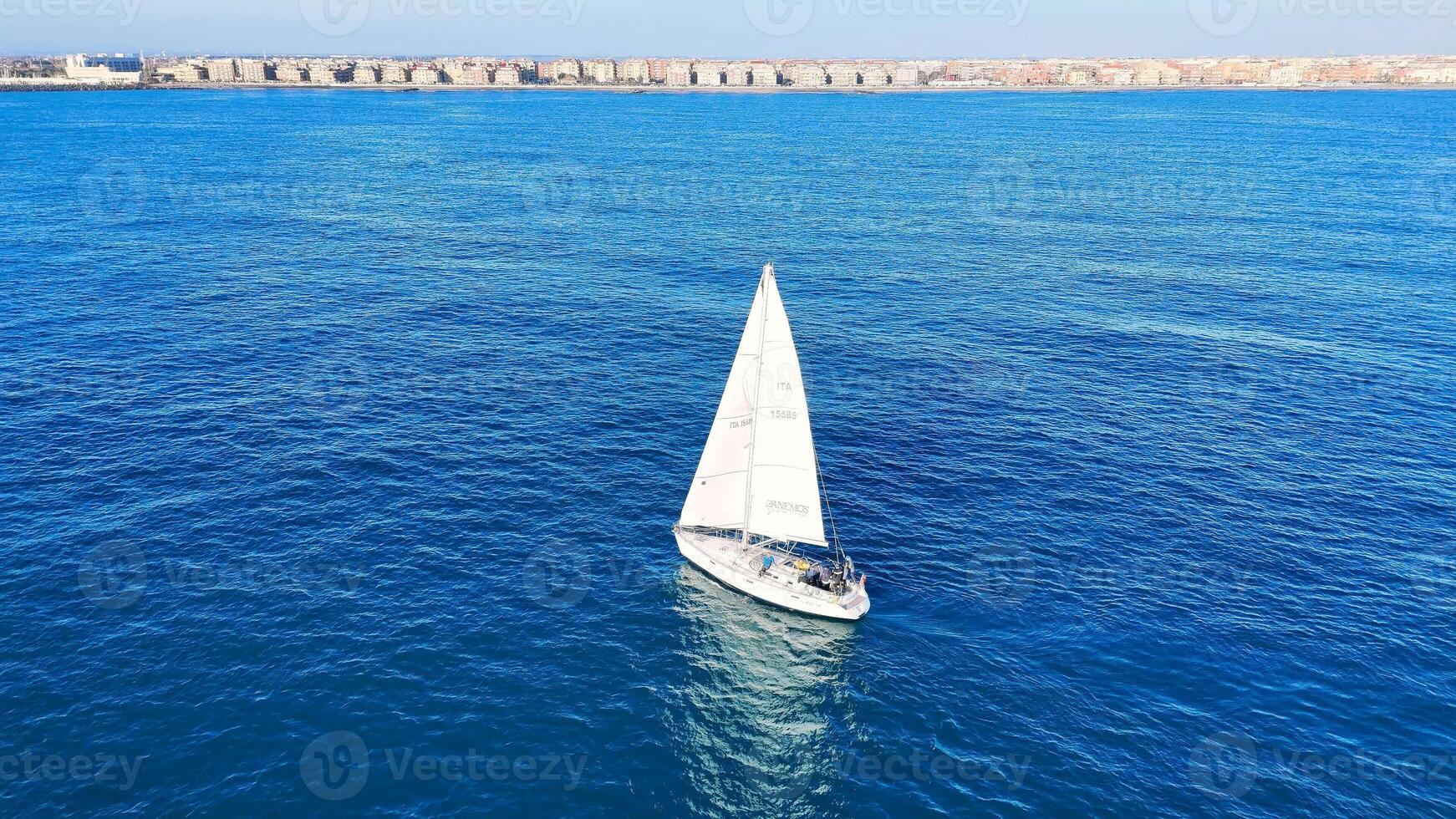 Sailing through tranquil waters near coastal cliffs on a sunny day with clear blue skies and distant land formations photo