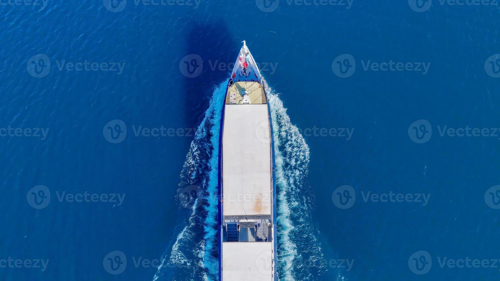 Cruising over the azure waters, a ship ventures towards the horizon in a tranquil maritime journey photo