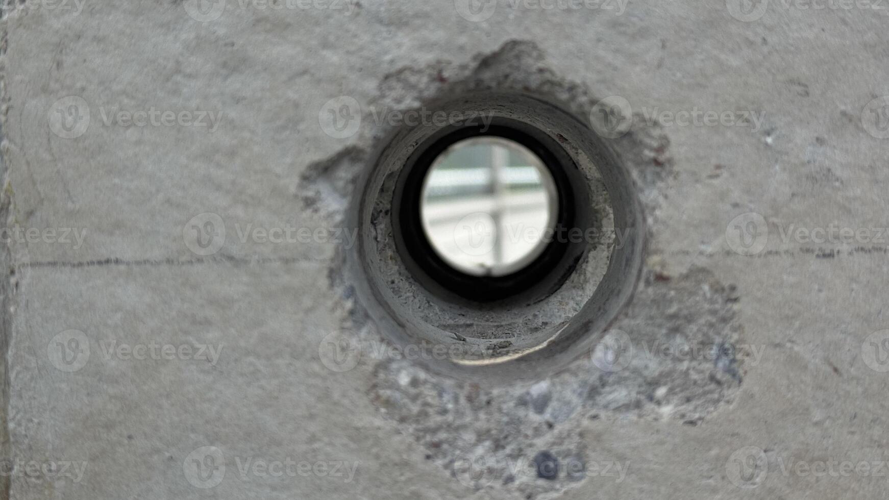 Concrete and Hole A close-up shot reveals the intricate texture and design of a weathered concrete pillar, highlighting a circular opening that draws the eye. photo