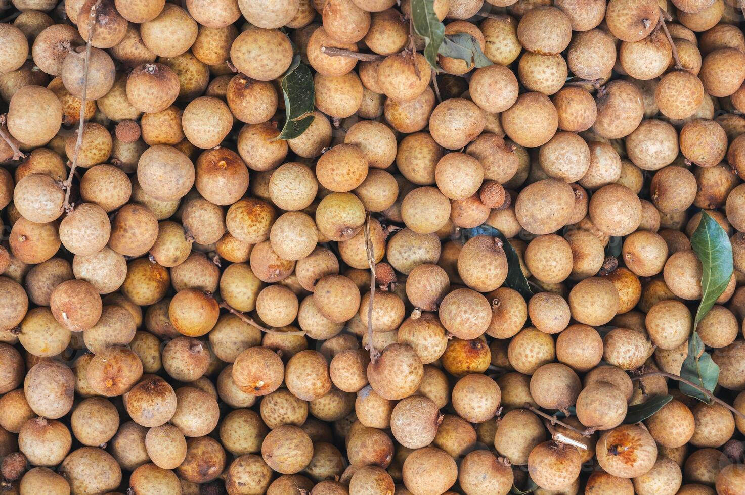 background with ripe longan. Exotic Asian fruits on counter in the market close-up photo