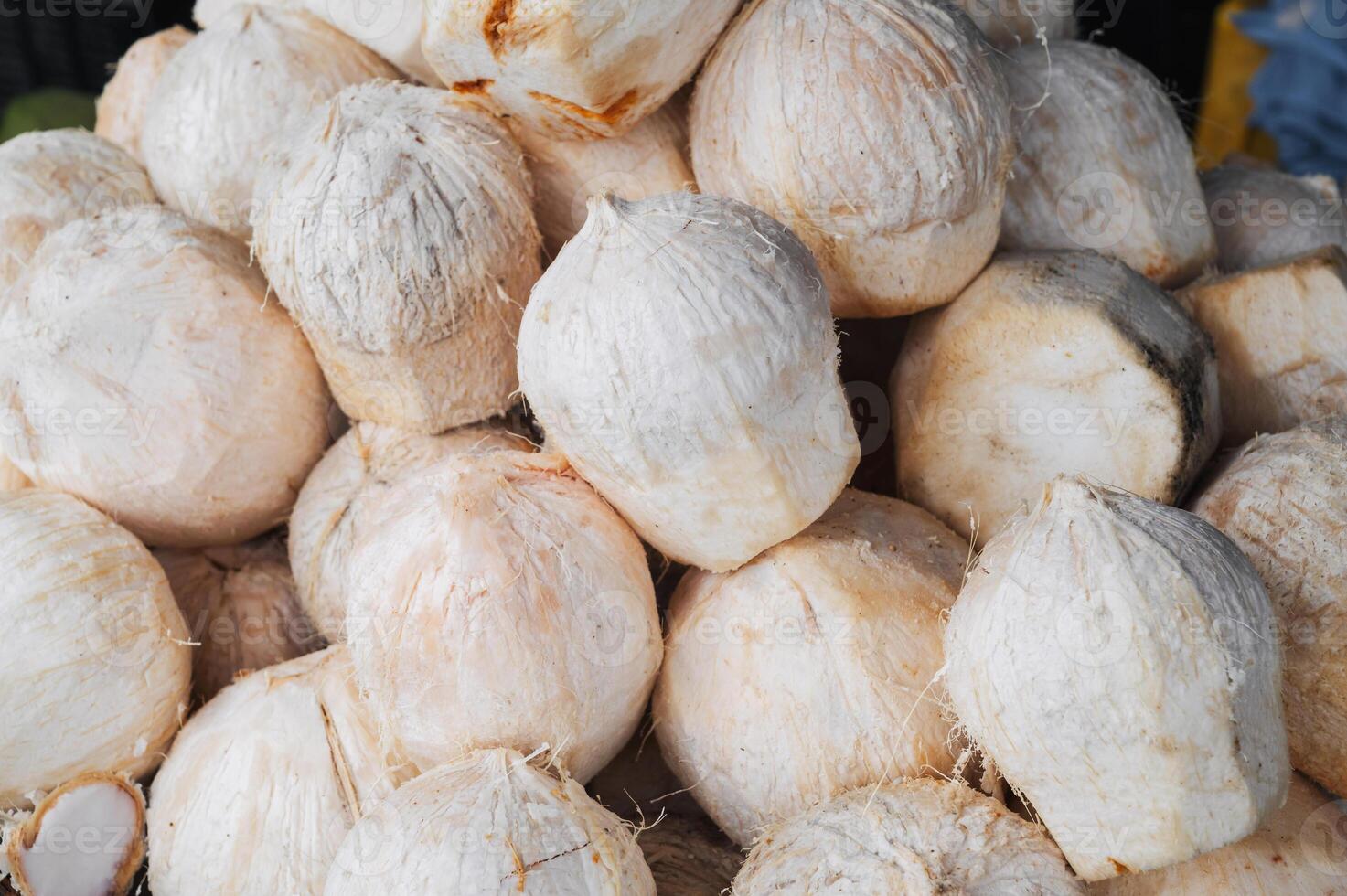 white young drinking coconuts on counter at Asian market close-up photo