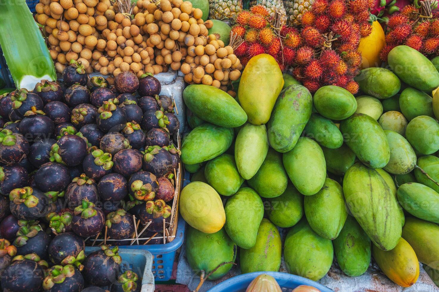 An assortment of various tropical exotic Asian fruits on counter at the market in Thailand photo