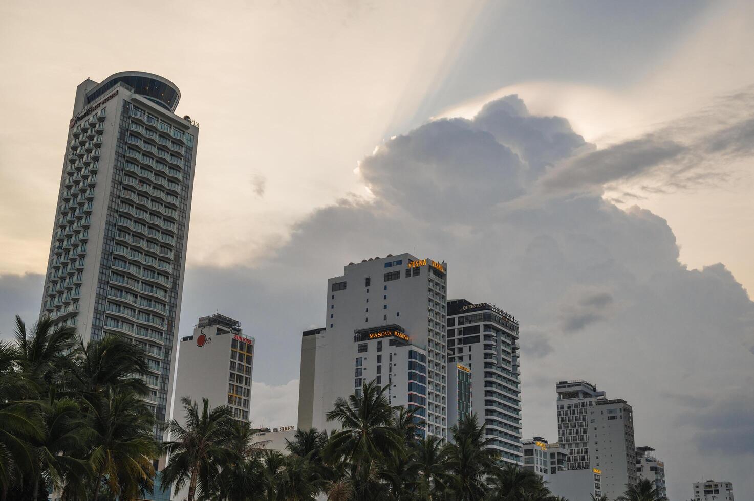 The buildings of the skyscrapers of the hotels on the background of the sunset sky in evening. Nha Trang, Vietnam - July 31, 2024 photo