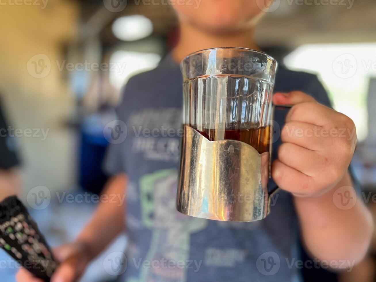 Child holding traditional russian tea glass in podstakannik on train photo