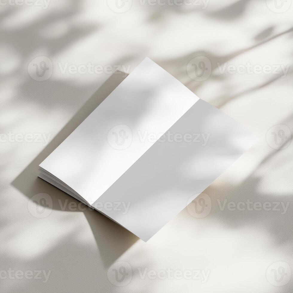 Blank white notebook on a table with shadow photo