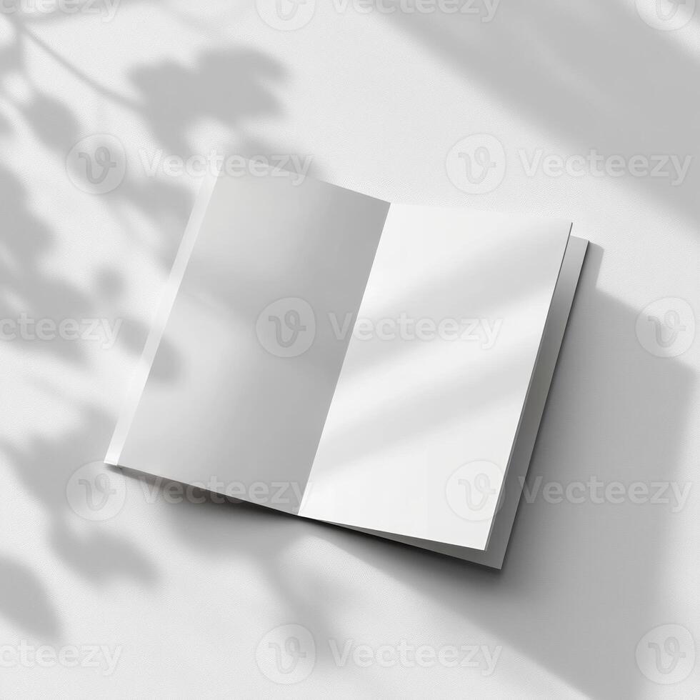 Blank white book on a white surface with shadow photo