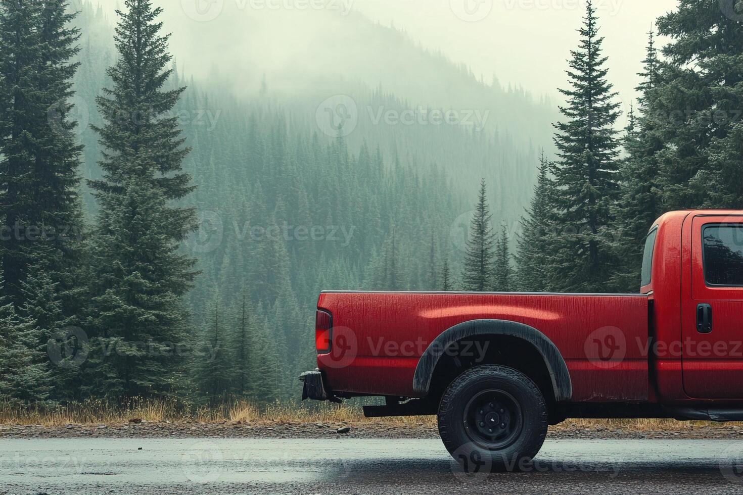 close-up side view of red pickup truck body parked on forest road with spruce forest and hills in background in cold cloudy weather photo