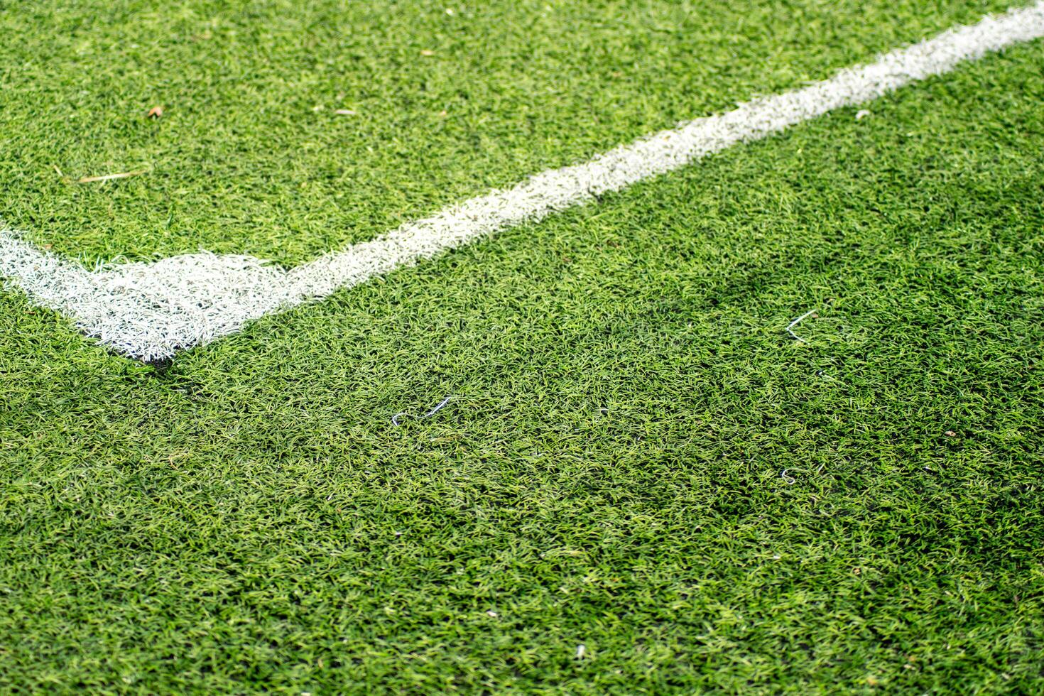 close view of a football soccer pitch corner area, detail of white lines on a green synthetic turf football pitch photo