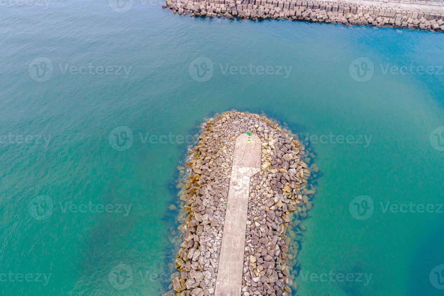 drone aerial view of a breakwater in the ocean, coastal infrastructure aerial view of a rocky jetty photo