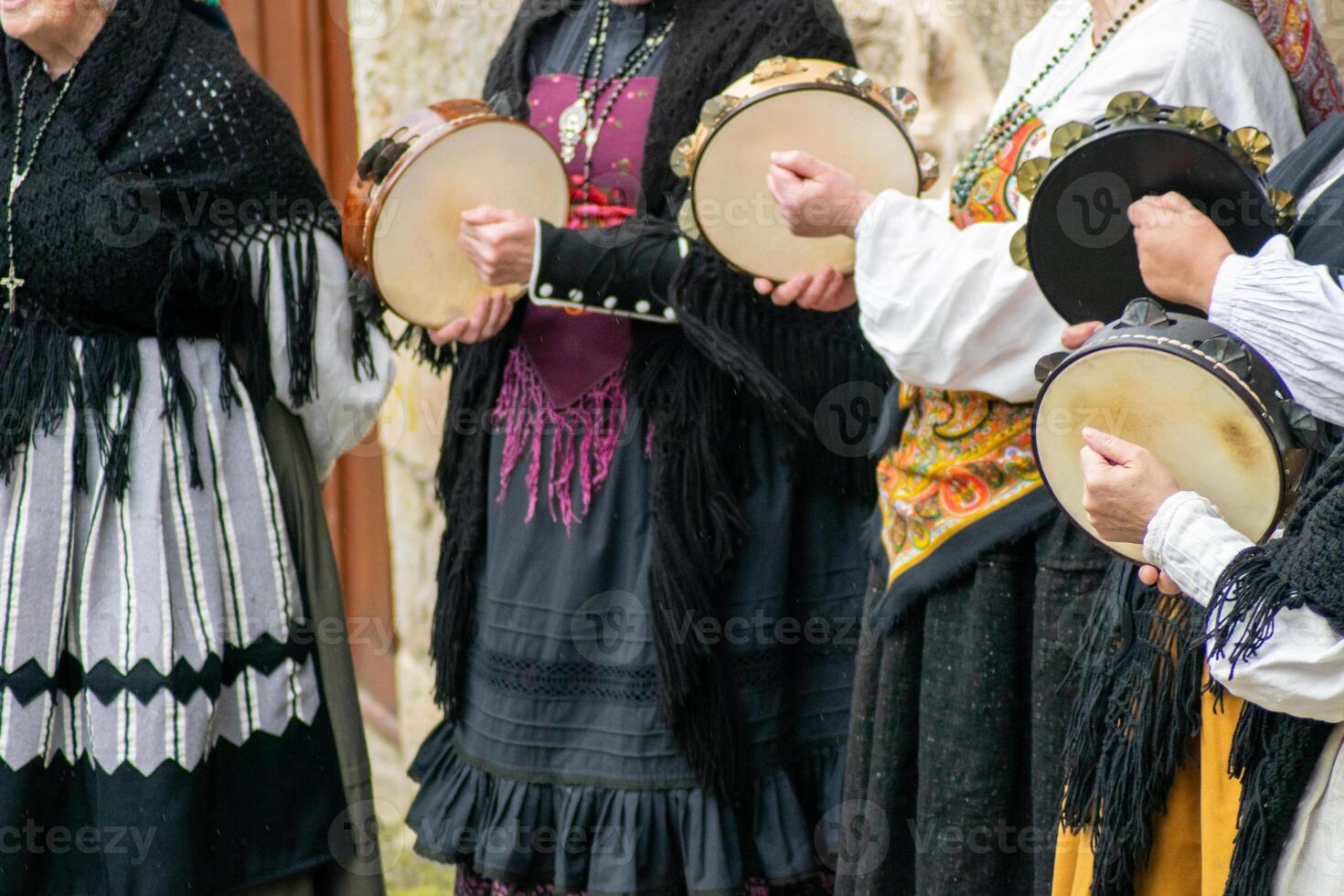 women playing the tambourine and dressed in the traditional old Galician style dancing at an ethnographic festival photo