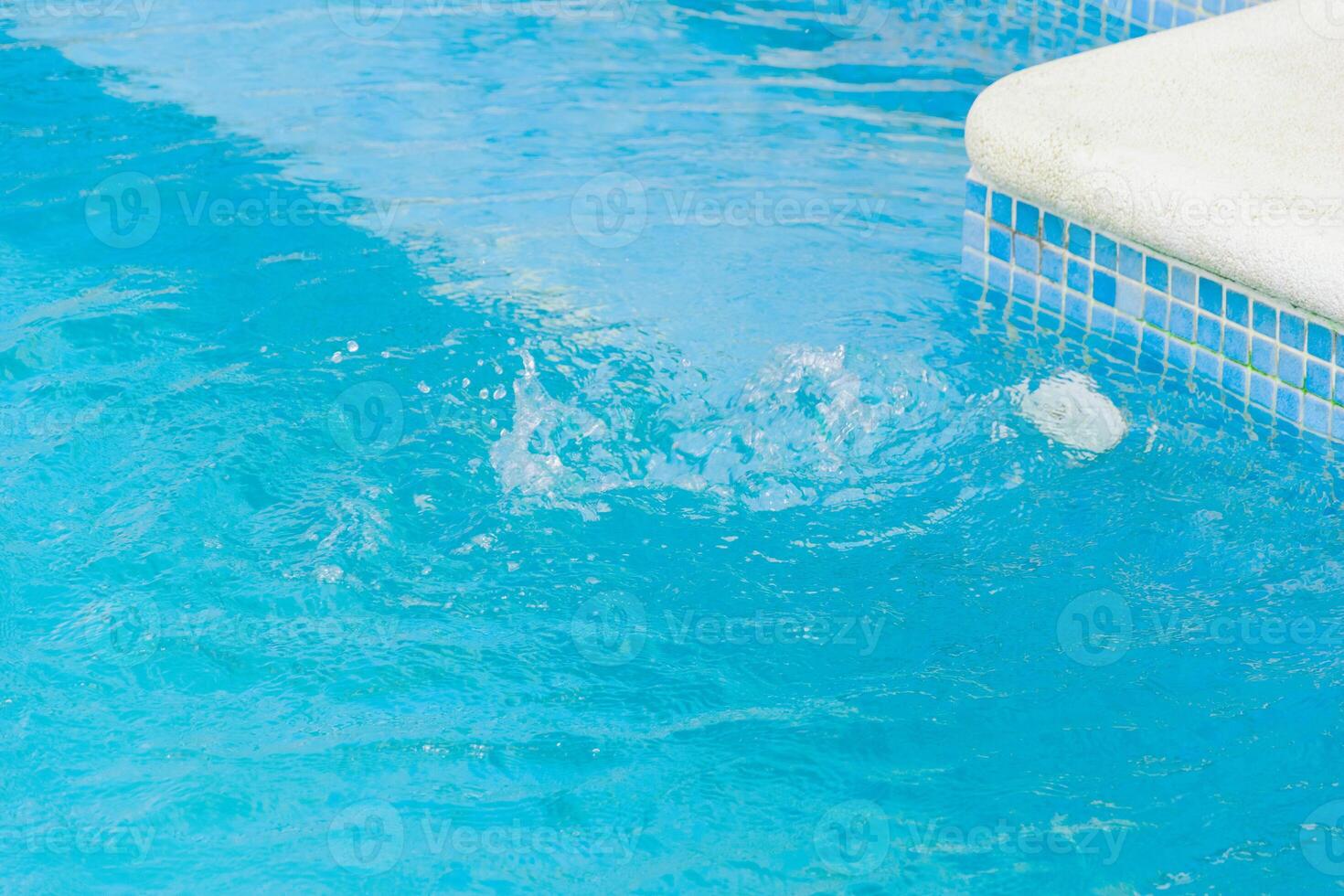 detail of a swimming pool edge and water movement swimming pool corner with mosaic tiles and splashing water photo