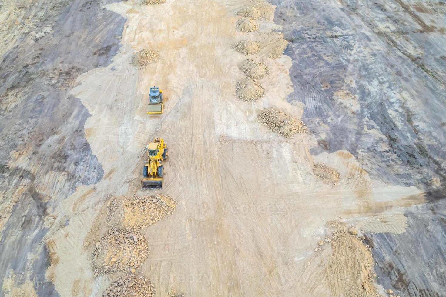 construction site from above with dirt piles and machinery drone view of earth moving and ground texture photo